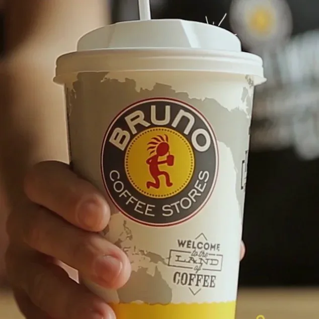 Χέρι κρατά ποτήρι καφέ Bruno Coffee Stores